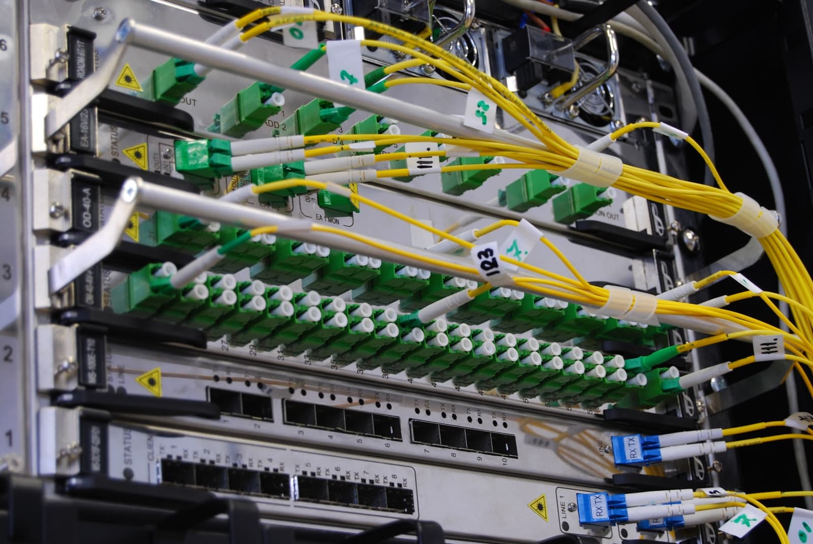 An optical distribution frame, yellow single-mode patch cords running into rows of green LC connectors
