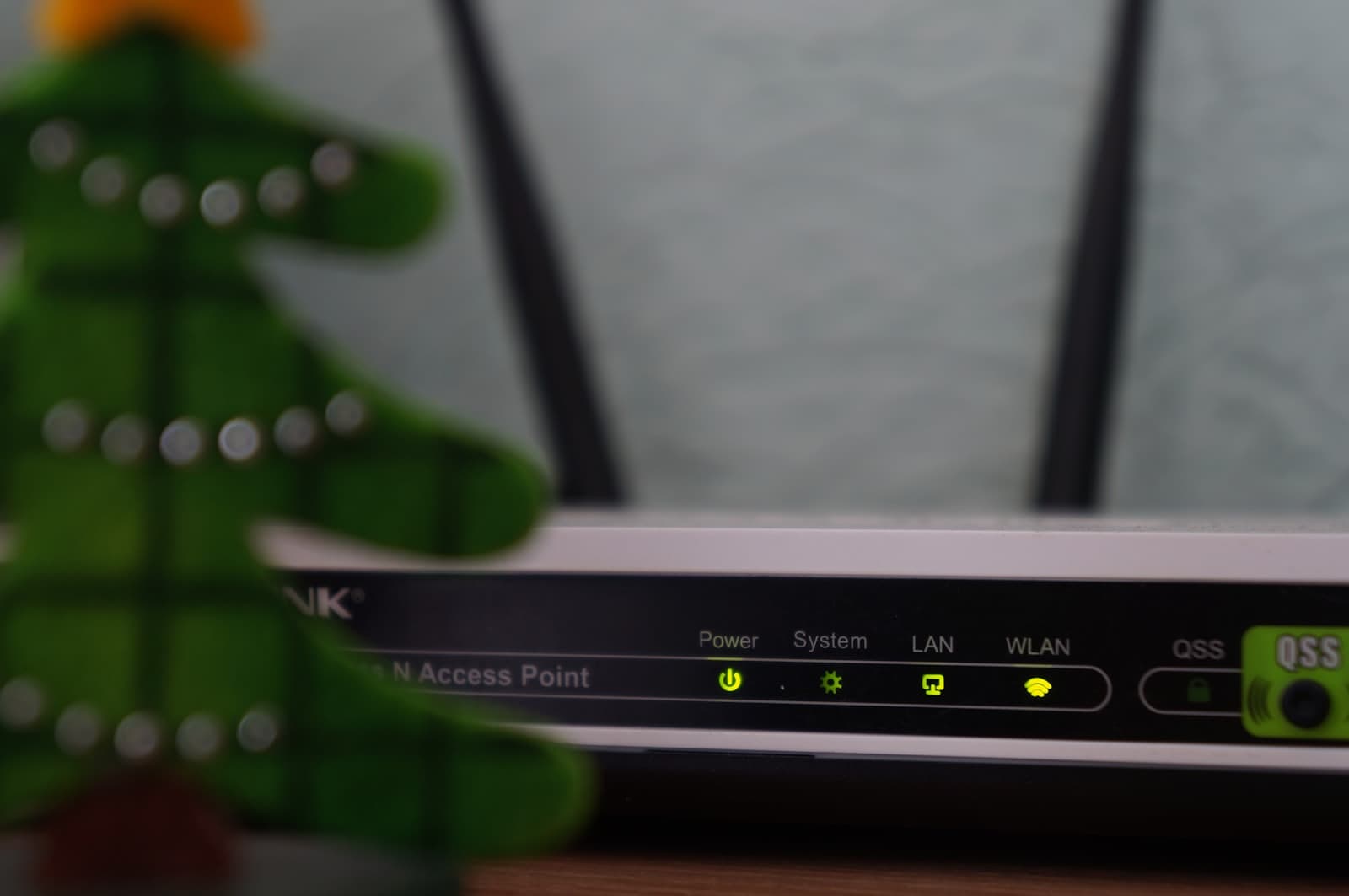 A wireless access point with two aerials, its power, LAN and WLAN indicators lit